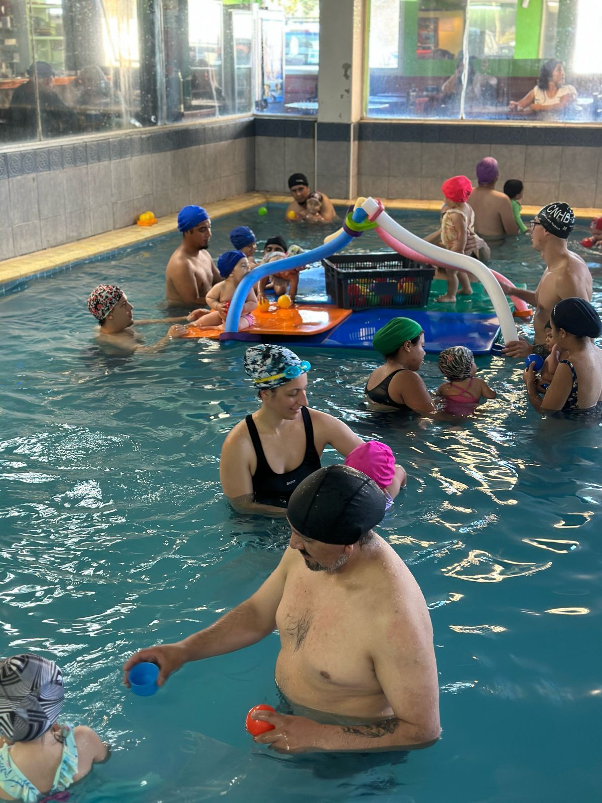 Un grupo de personas está nadando en una piscina.