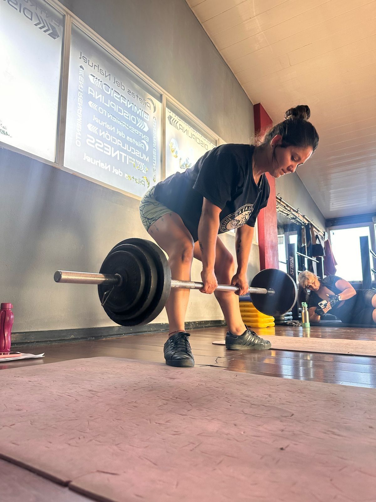 Una mujer está levantando una barra en un gimnasio.