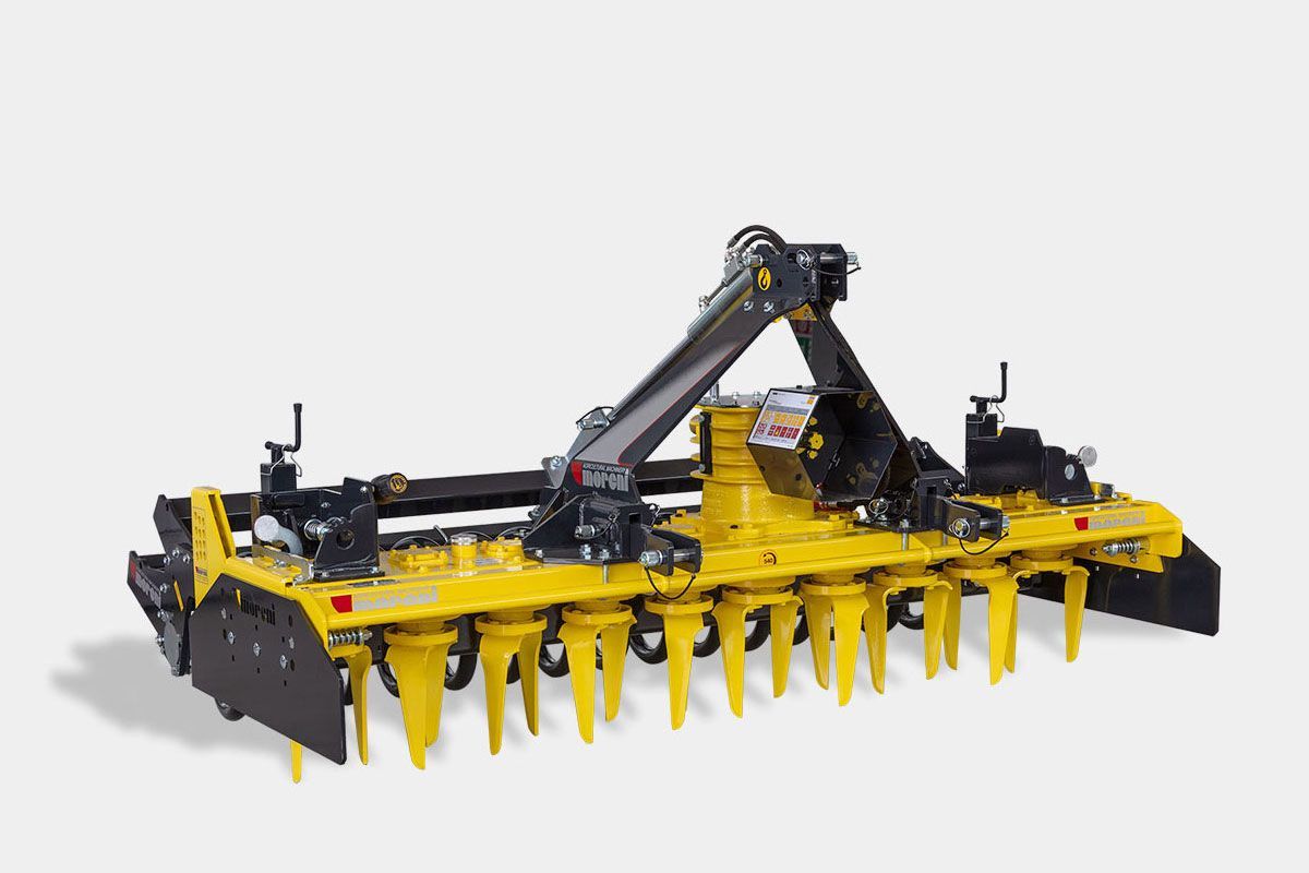 A yellow and black power harrow is sitting on a white surface.