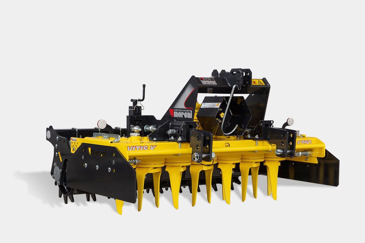 A yellow and black power harrow is sitting on a white surface.