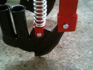 A close up of a red and black object with a spring attached to it.