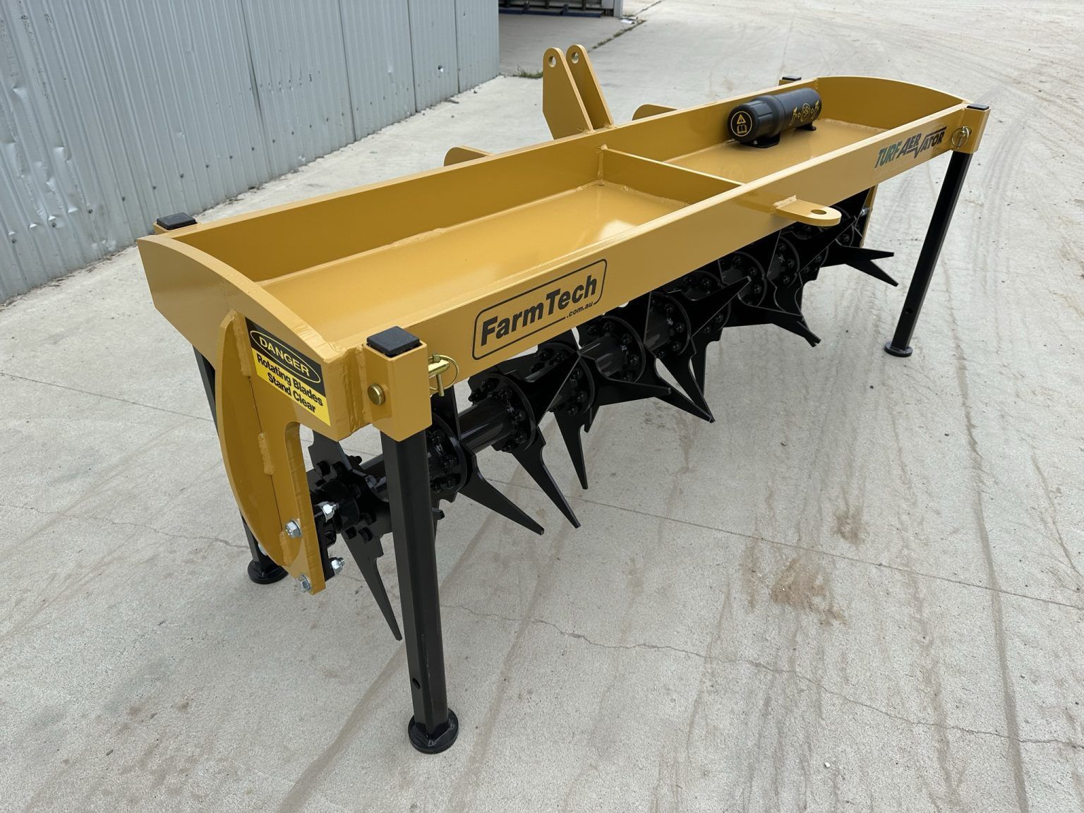 A yellow and black machine is sitting on a concrete surface.