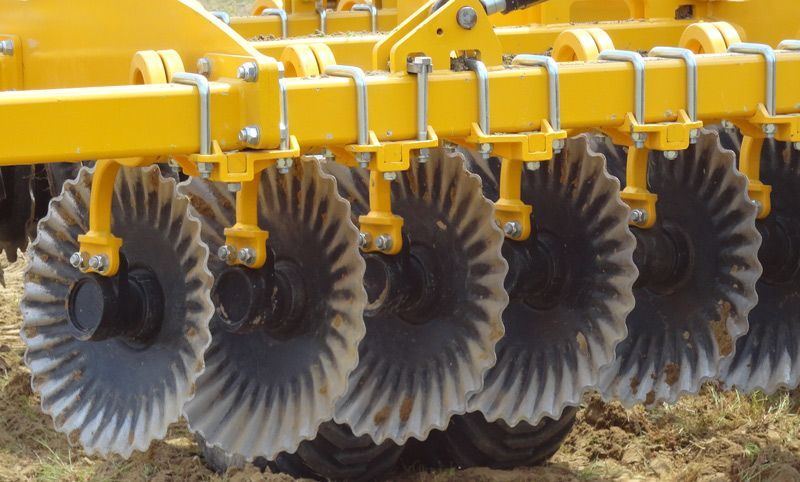 A close up of a yellow and black tractor in a field