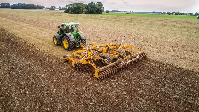 An aerial view of a tractor plowing a field.