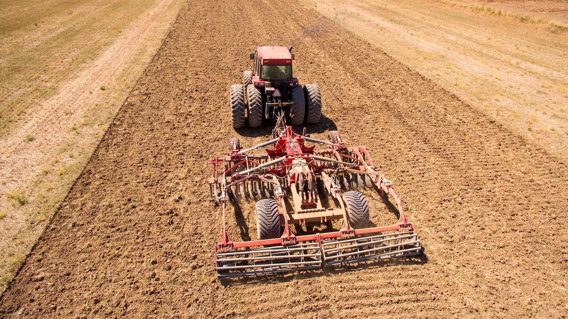 A unia disc tiller is parked in a grassy field