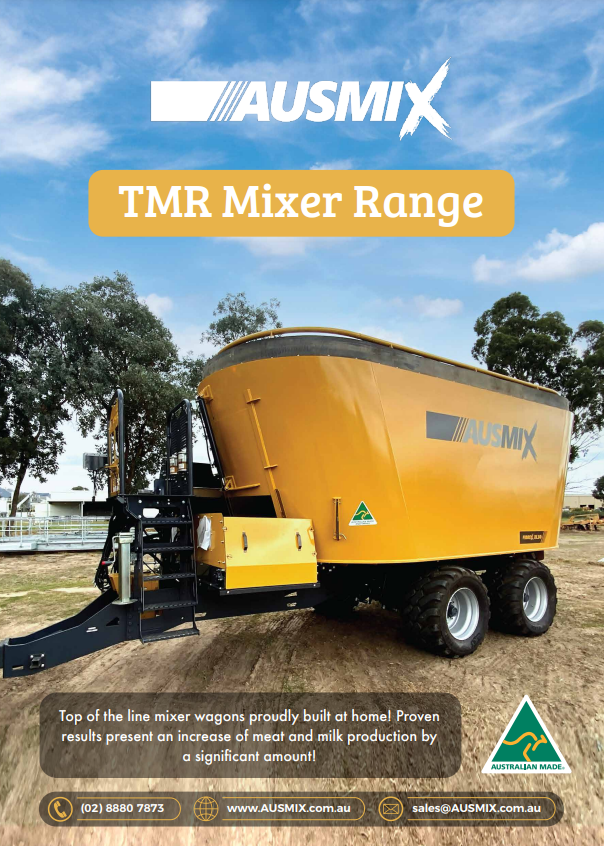 A yellow mixer is sitting on top of a trailer in a field.