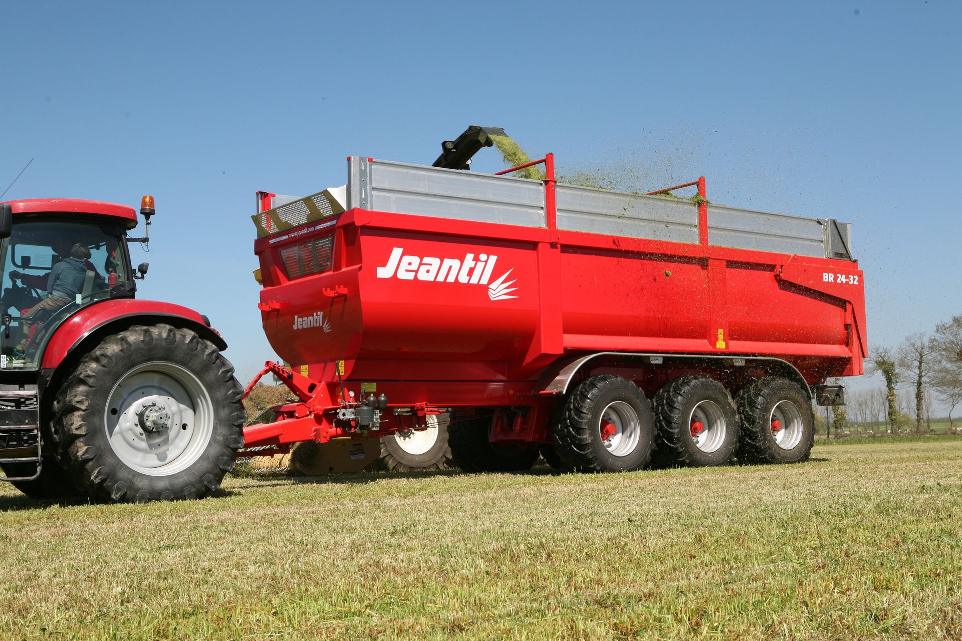A large tanker truck is parked in a grassy field.