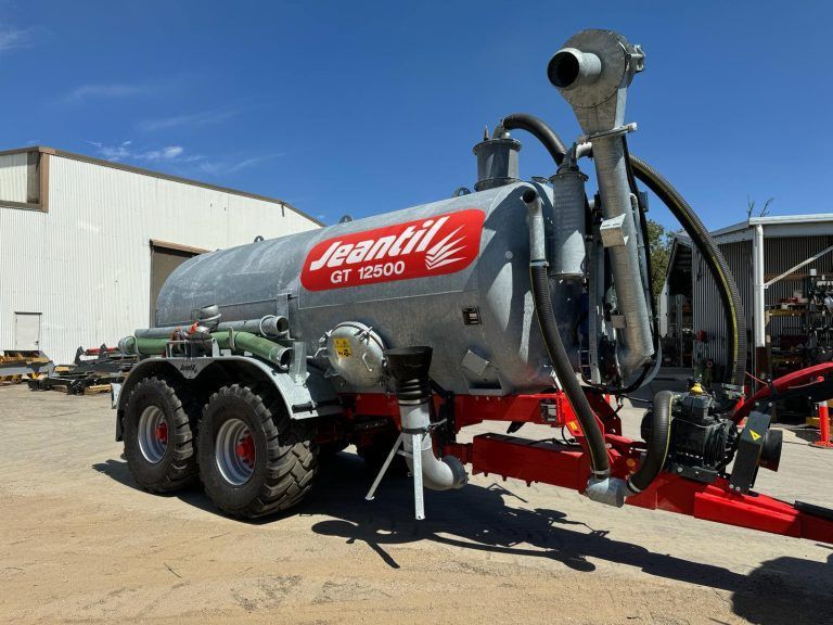 A large gray and red jeantil tank is parked in a parking lot