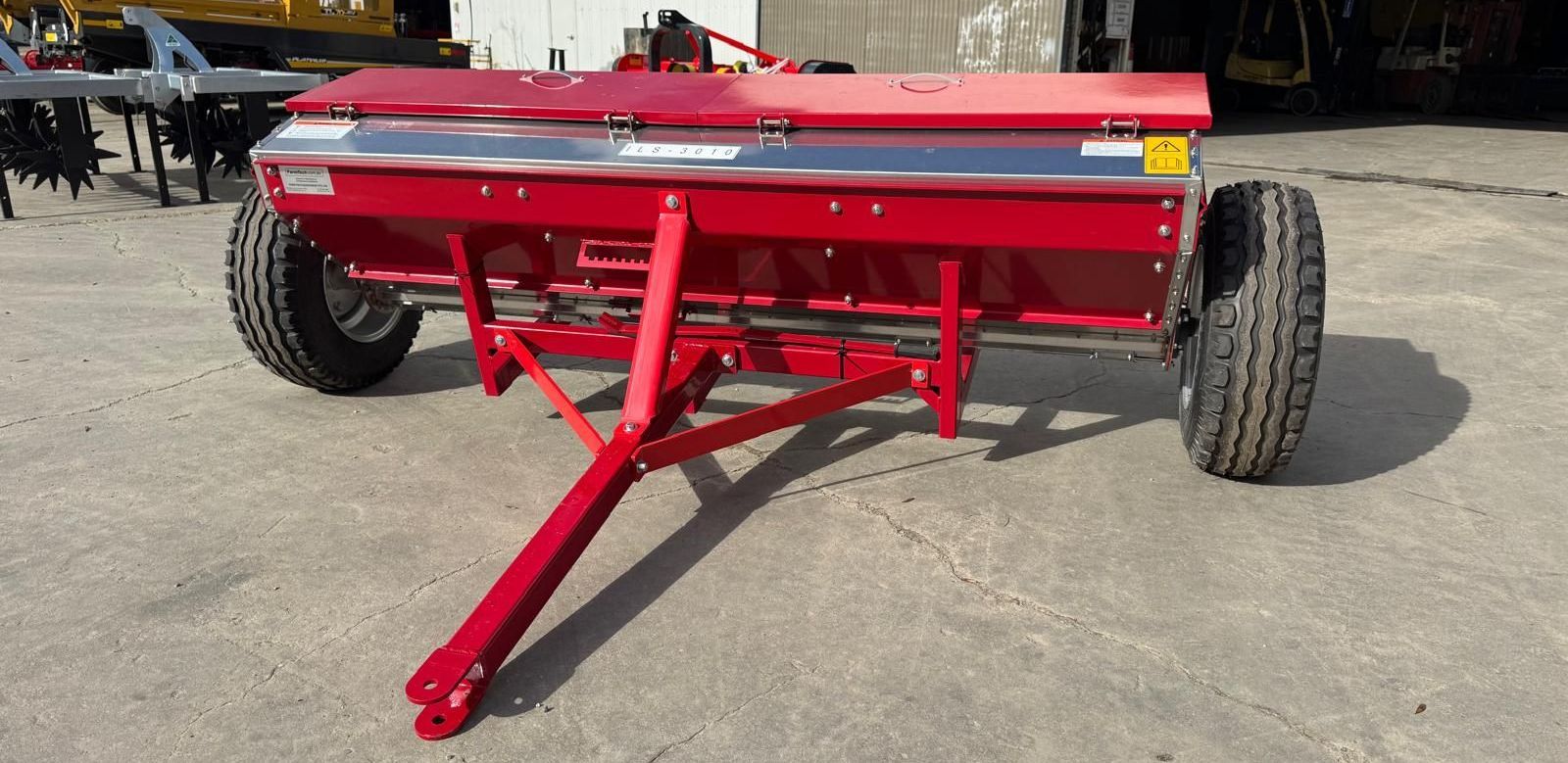 A spreader is attached to the back of a tractor