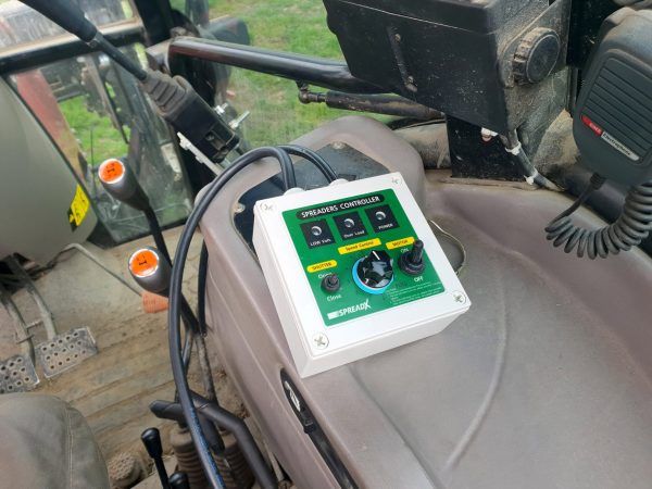 A remote control is sitting on the dashboard of a tractor