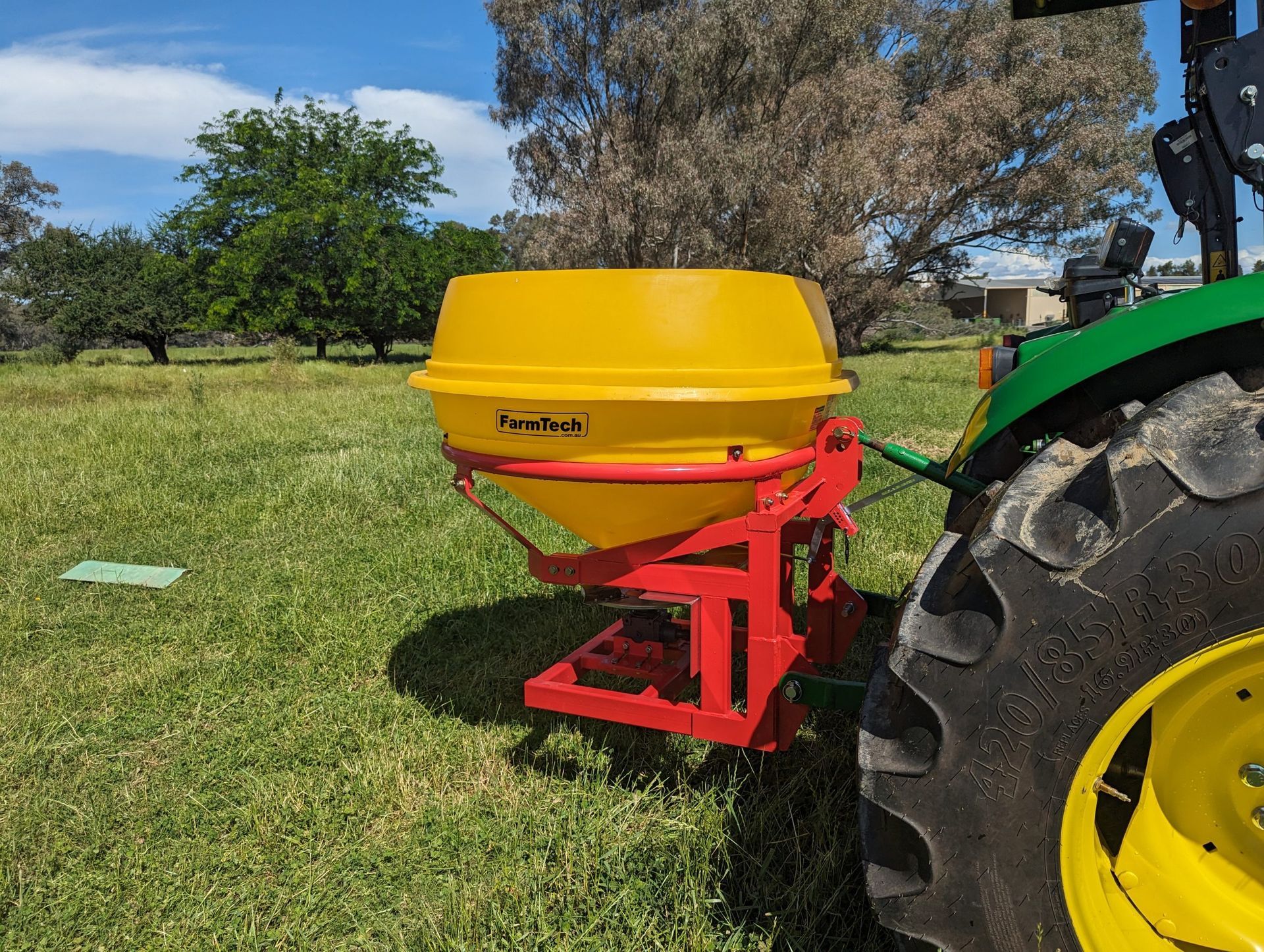 A yellow and red tractor is parked in a grassy field.