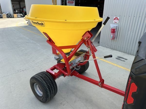 A yellow and red spreader is attached to a tire