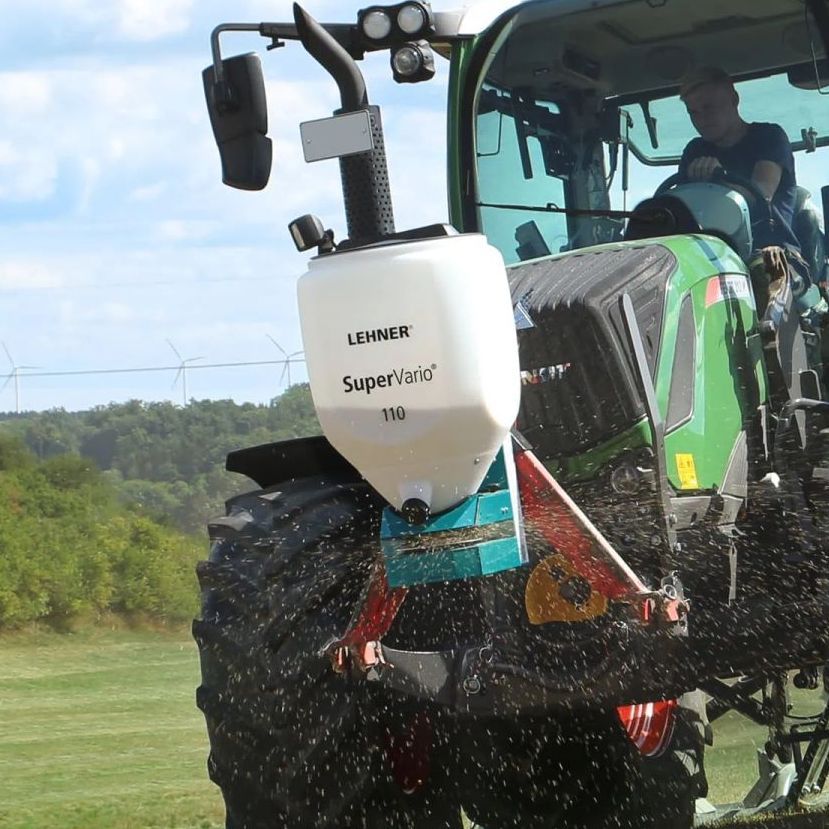 A green tractor with a white container that says lehner on it