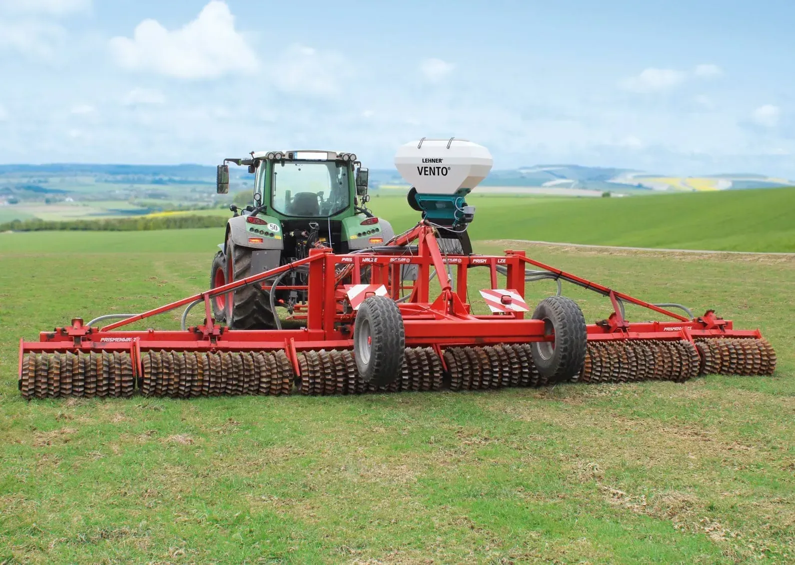 A tractor is rolling a field.