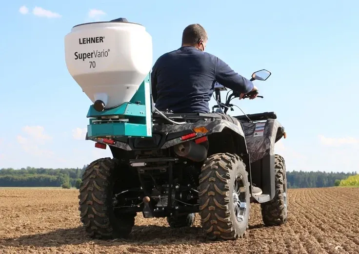 A man is riding a four wheeler in a field.