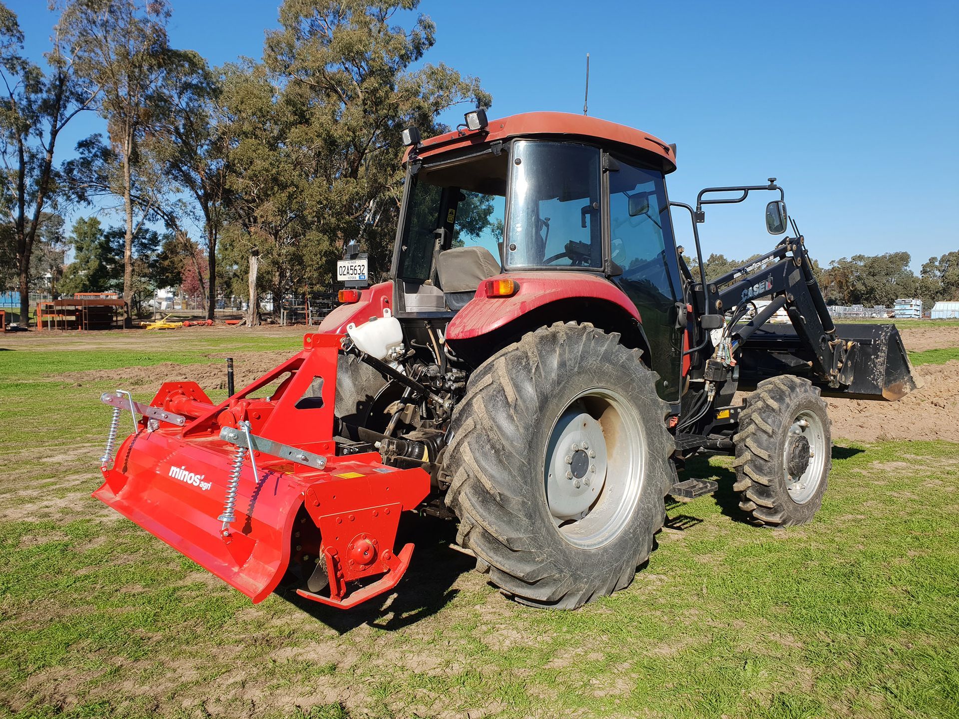 A yellow and black disc tiller is parked in a grassy field.