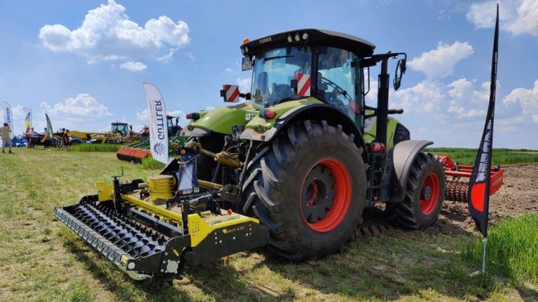 A tractor with a plow attached to it is parked in a field.