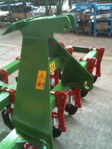 A green tractor with red wheels is sitting on the ground.