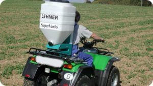 A man is riding a green atv in a field.