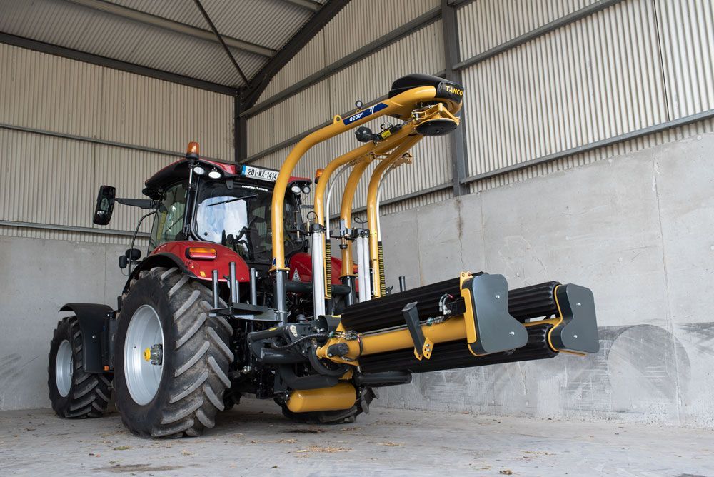 A red and yellow tractor is parked in a warehouse.