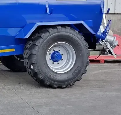 A blue truck with a large tire on it
