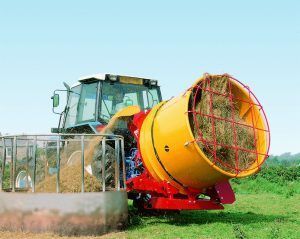 A tractor is baling hay in a field.