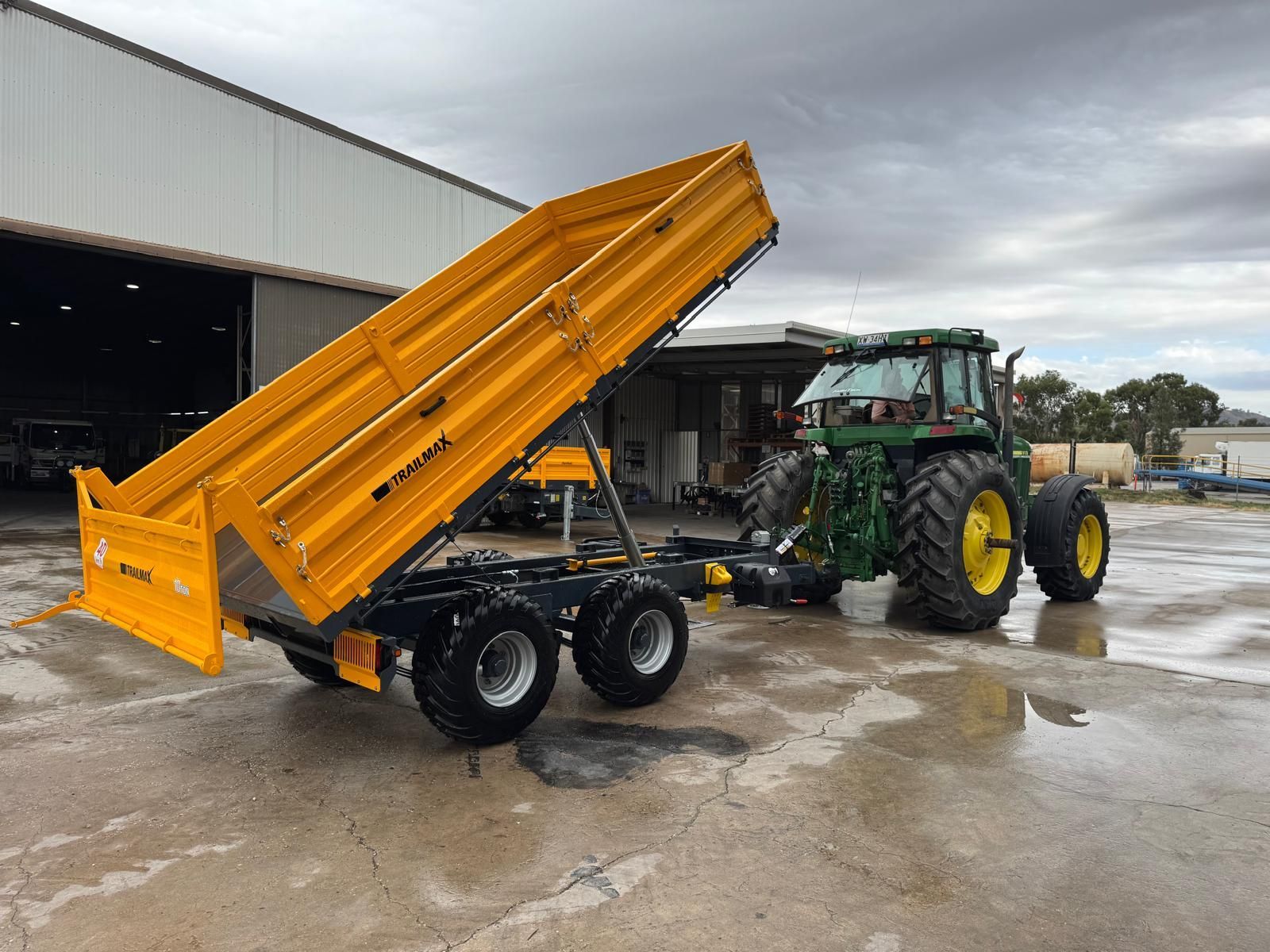 A tractor with a yellow dump trailer attached to it