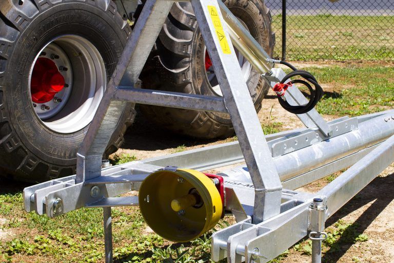 A tractor is parked in a grassy field with a trailer attached to it.