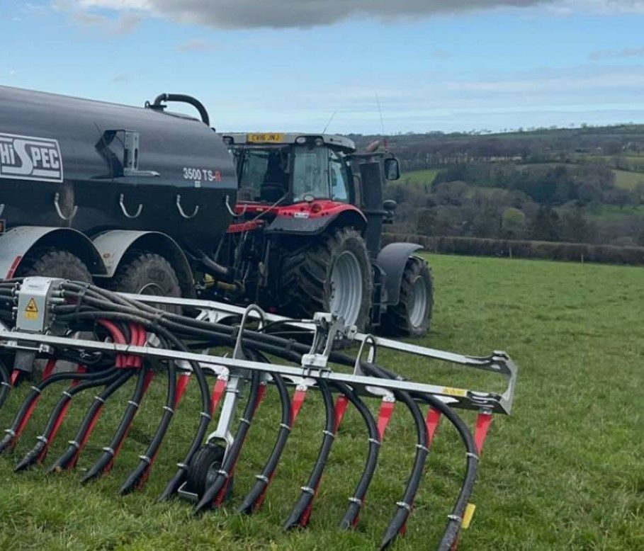 A tractor is spreading slurry on a field.