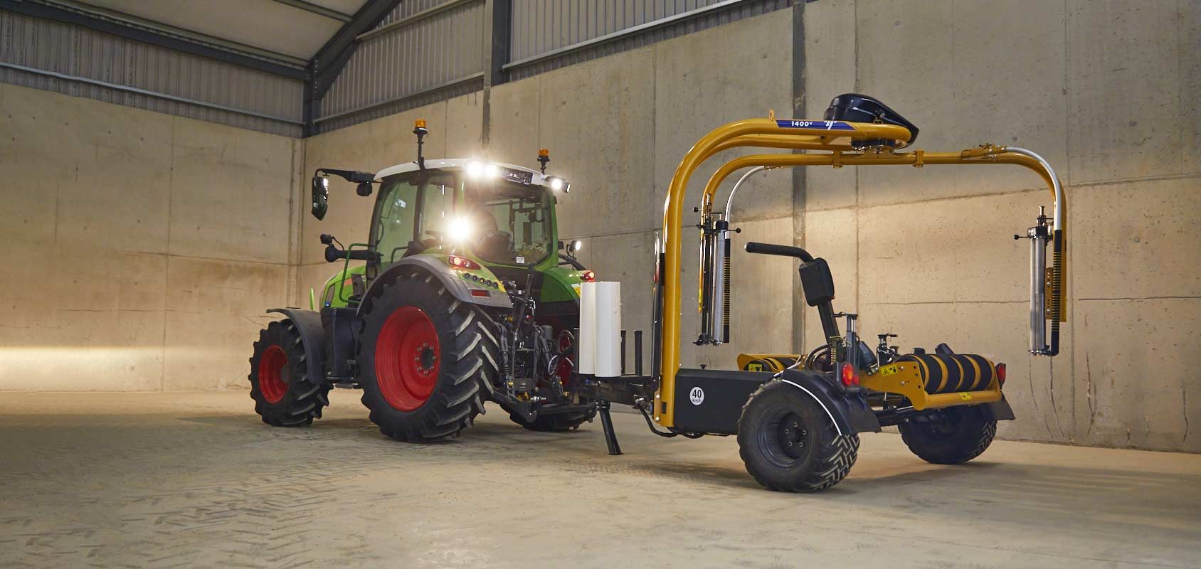 A tractor is pulling a trailer with a machine attached to it.
