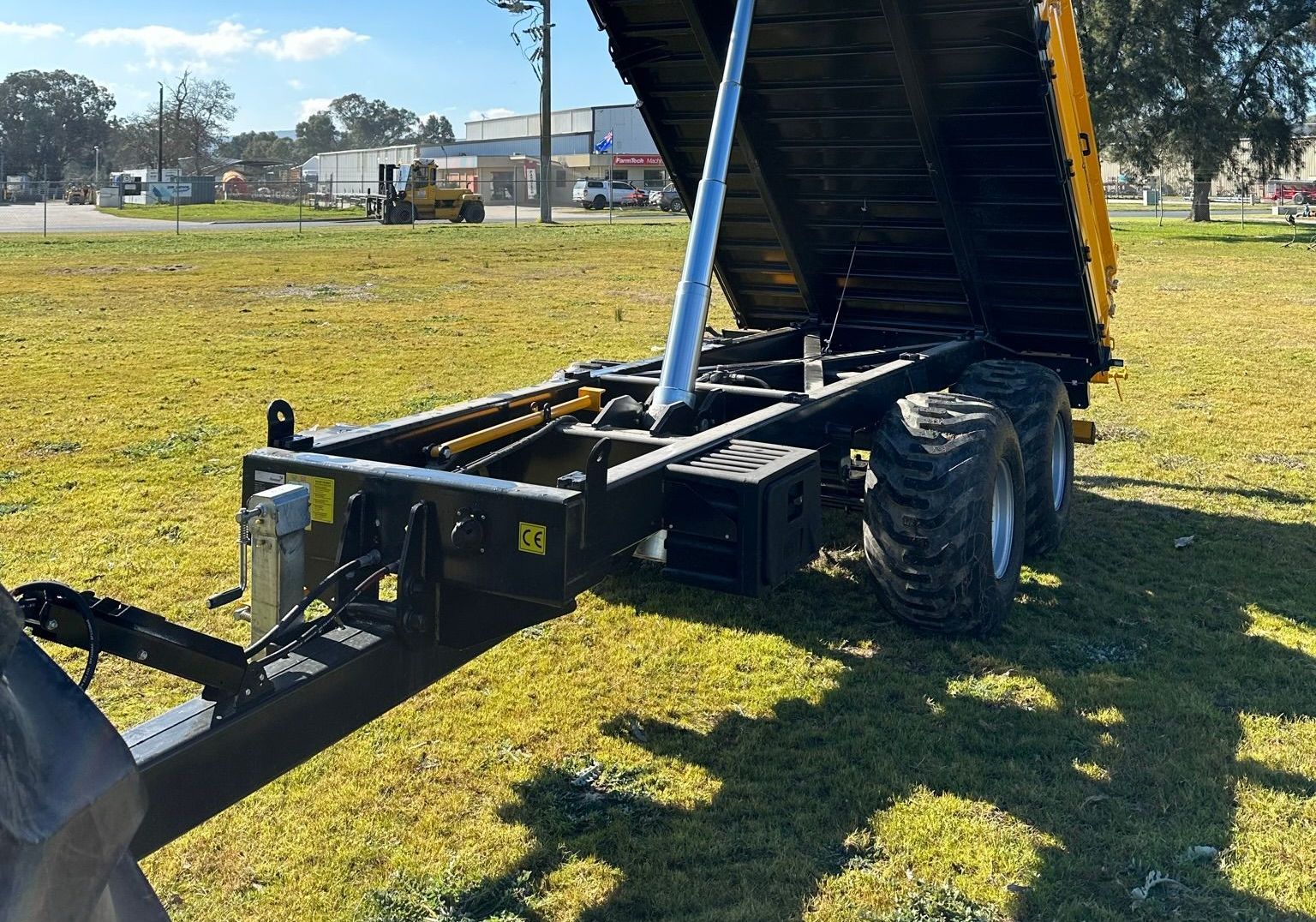A dump truck is parked in a grassy field.
