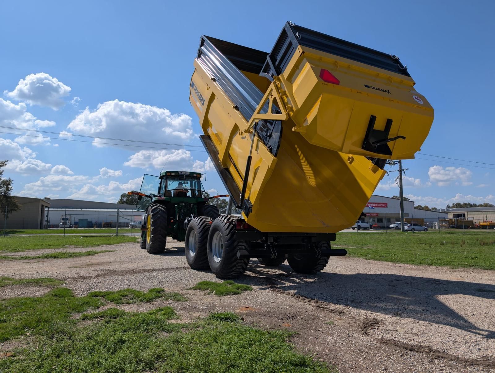 A tractor with a yellow dump trailer attached to it