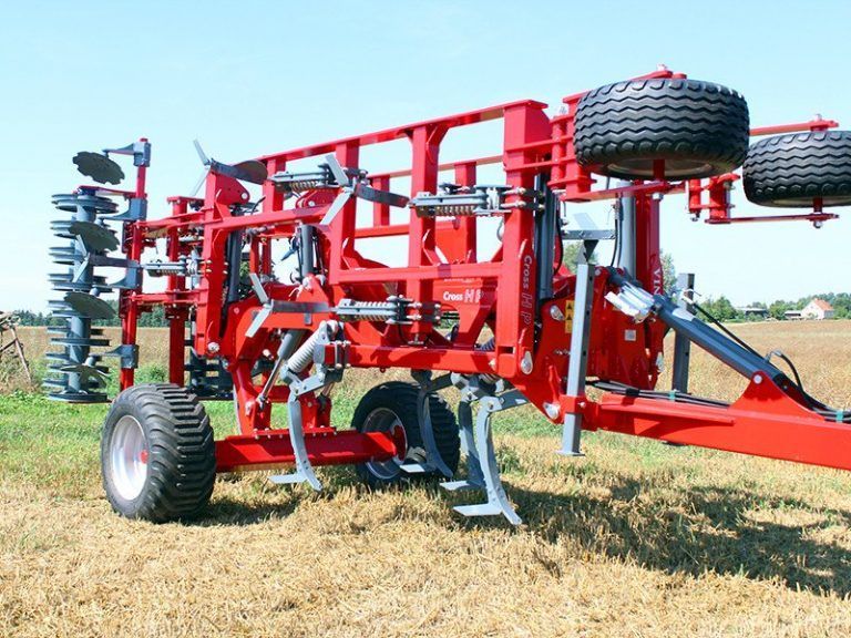 A large red tractor is parked in a field