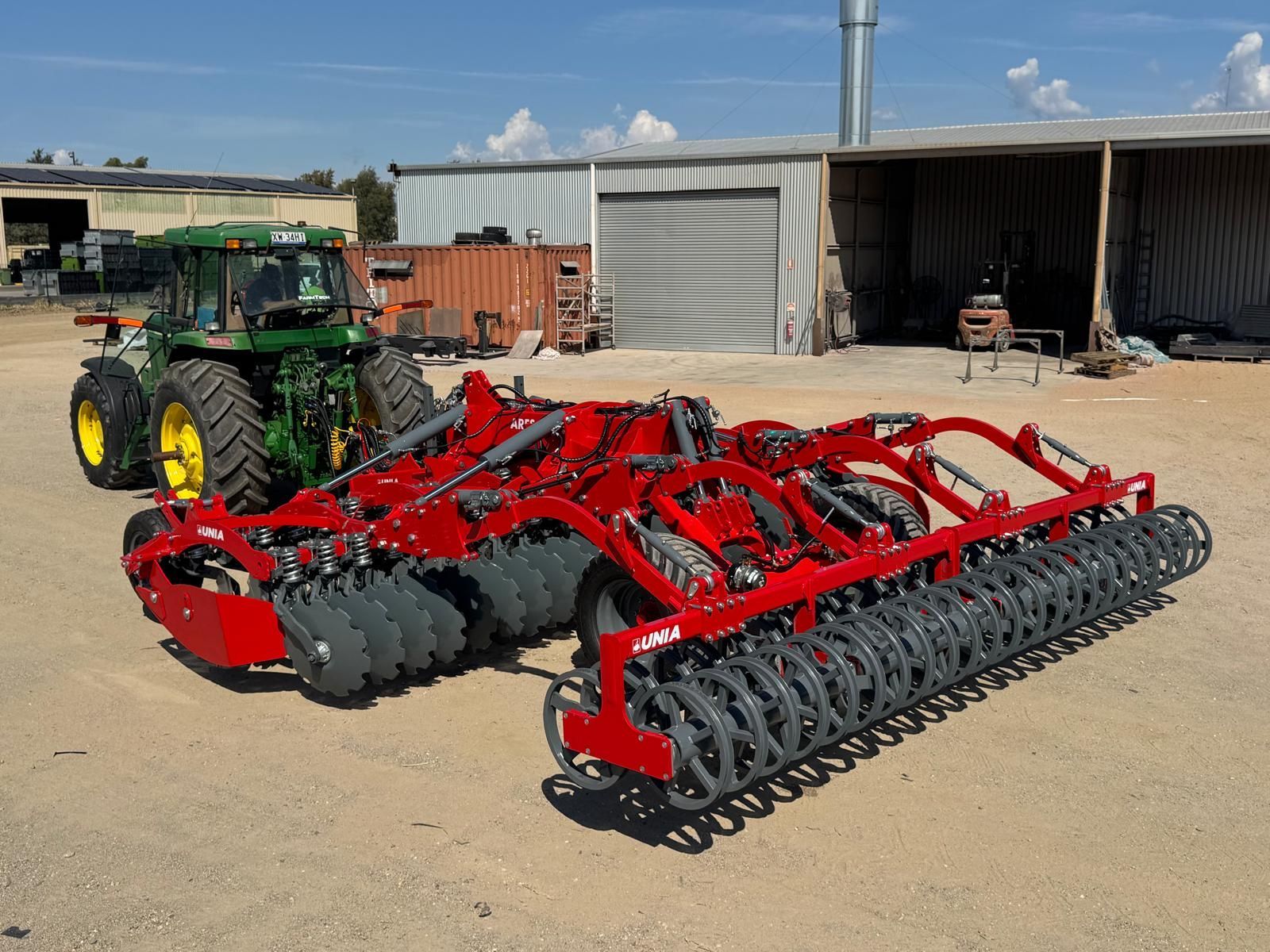 A red tractor is parked in the middle of a field