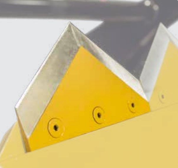A close up of a yellow object with three holes in it.