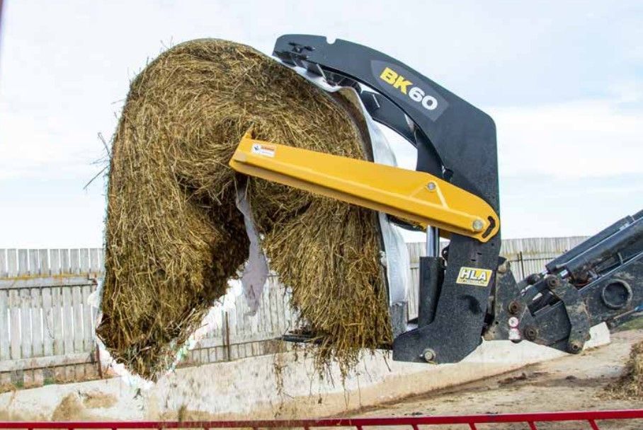 A large bale of hay is being lifted by a machine.