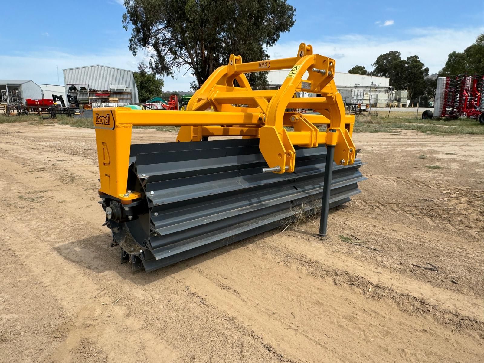 A yellow and black machine is sitting on top of a dirt field.