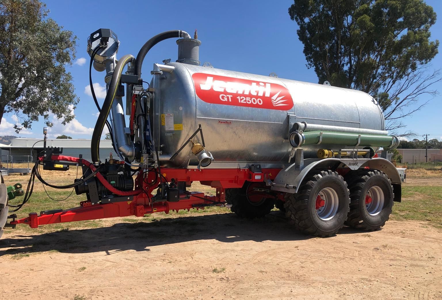 A large slurry tanker is parked in a grassy field.