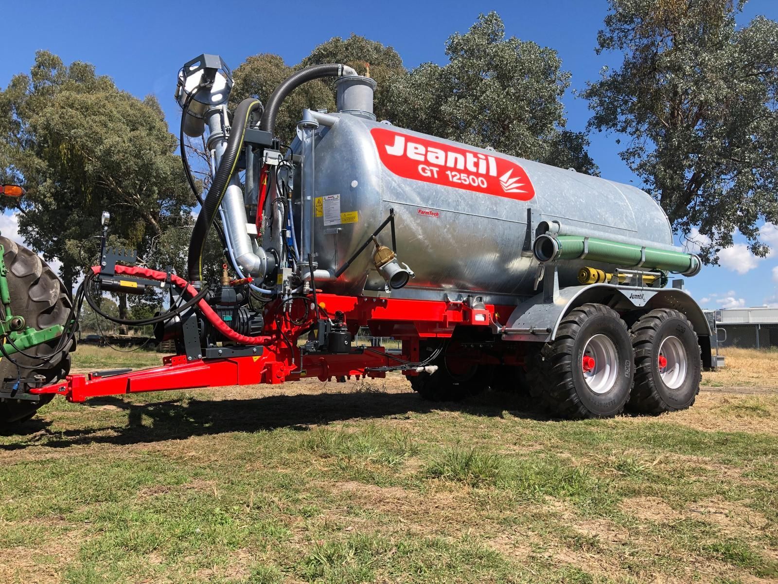 A large tanker truck is parked in a grassy field.