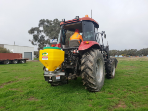 A red tractor is parked in a grassy field.