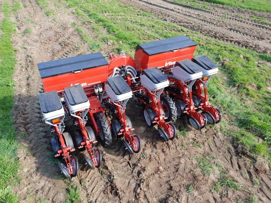 A pneumatic precision planter sitting in a field.