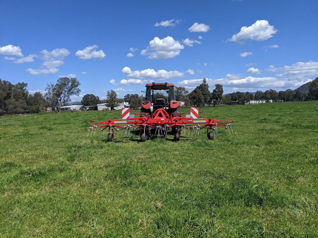 A tractor is driving through a grassy field.