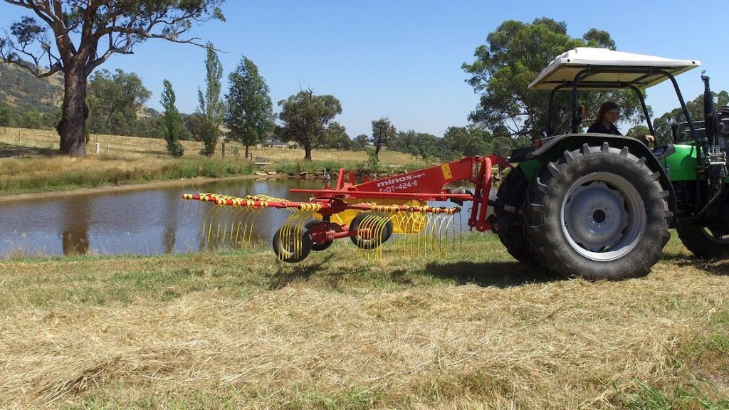A tractor is parked in a field next to a body of water