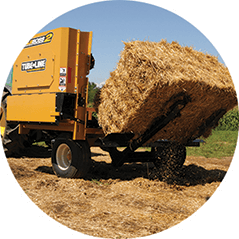 A large bale of hay is being loaded onto a trailer.