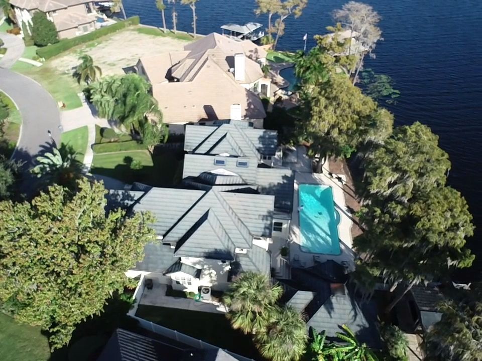 An aerial view of a house next to a lake