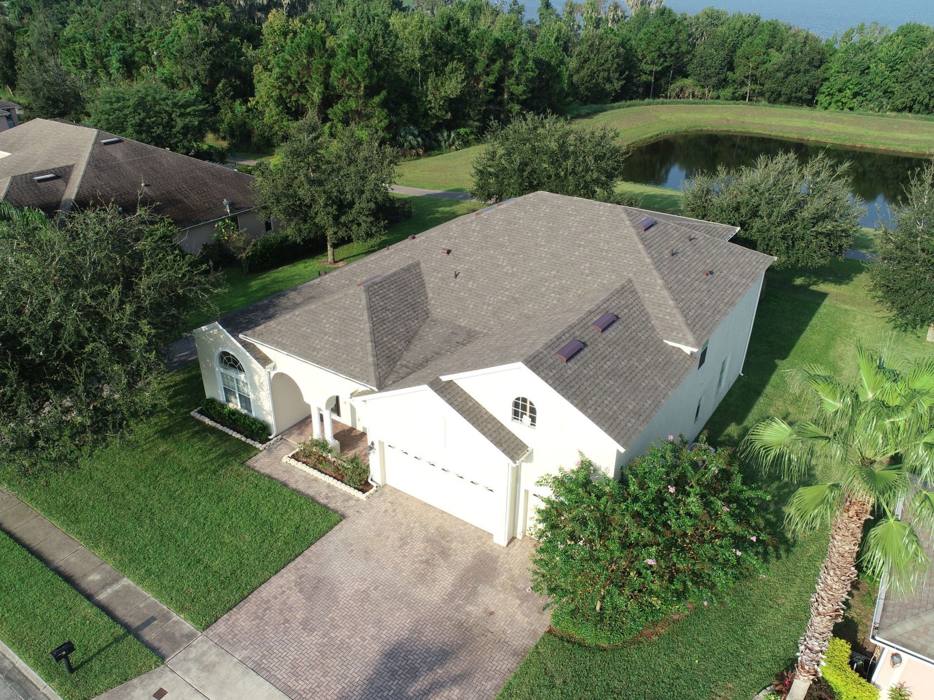 An aerial view of a house with a lake in the background