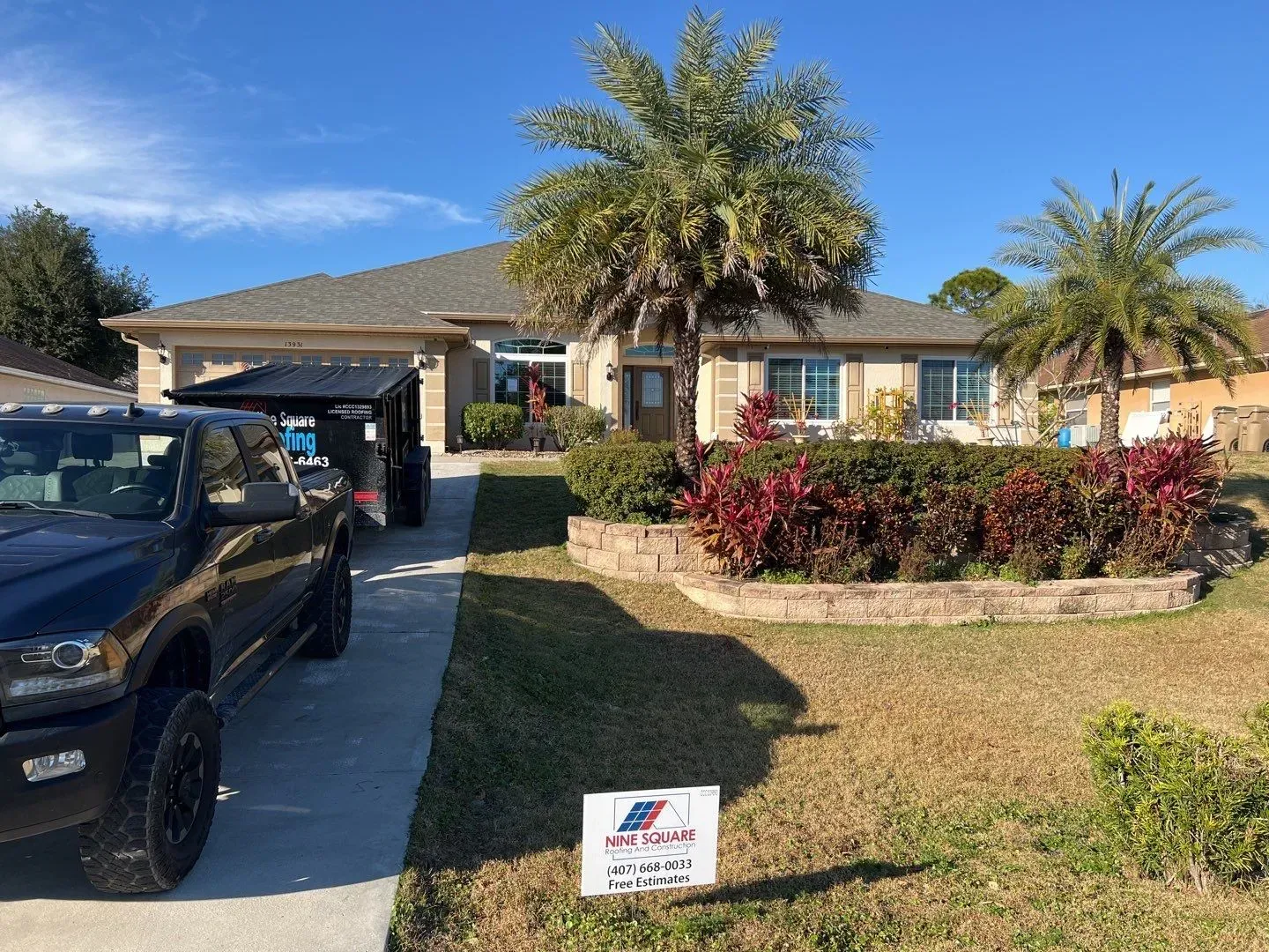 A truck is parked in front of a house with a sign in front of it.