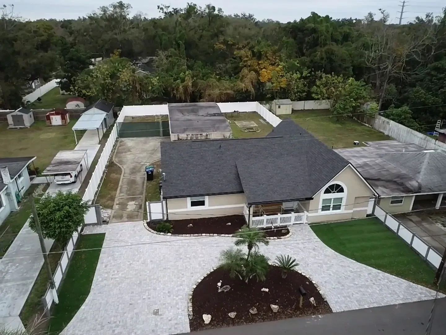 An aerial view of a house with a large driveway