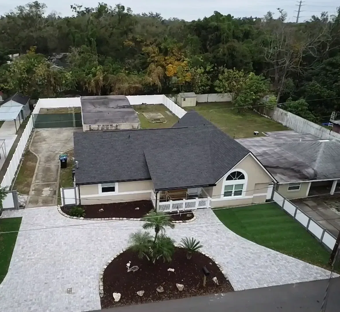 An aerial view of a house with a gray roof