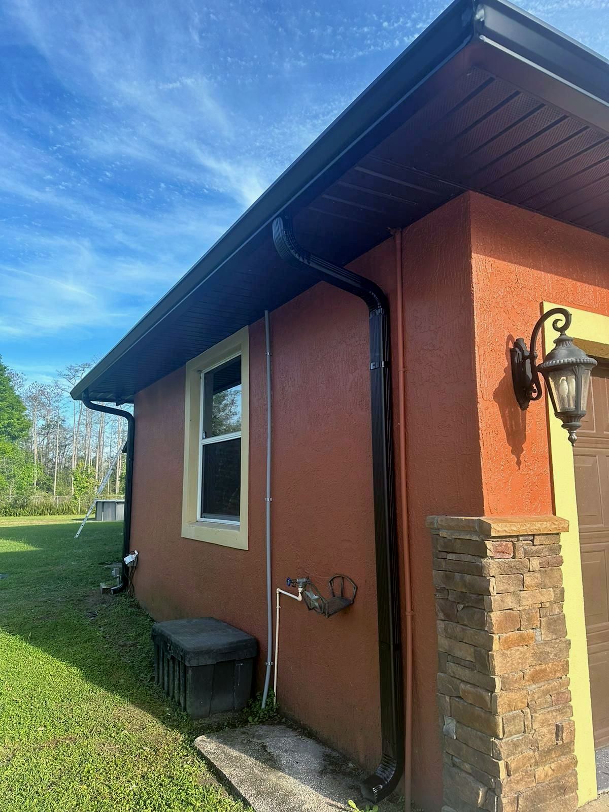 A house with a gutter on the side of it and a window.